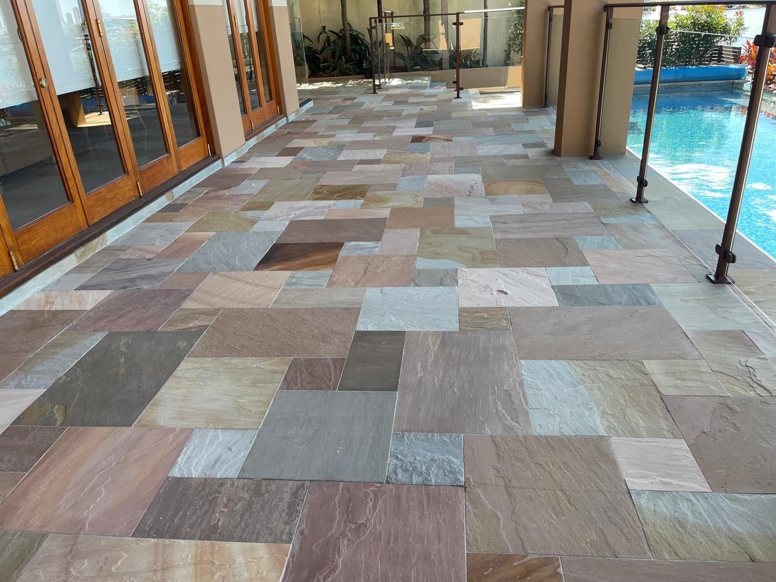 Multicolour Indian Sandstone alfresco paving beside a swimming pool