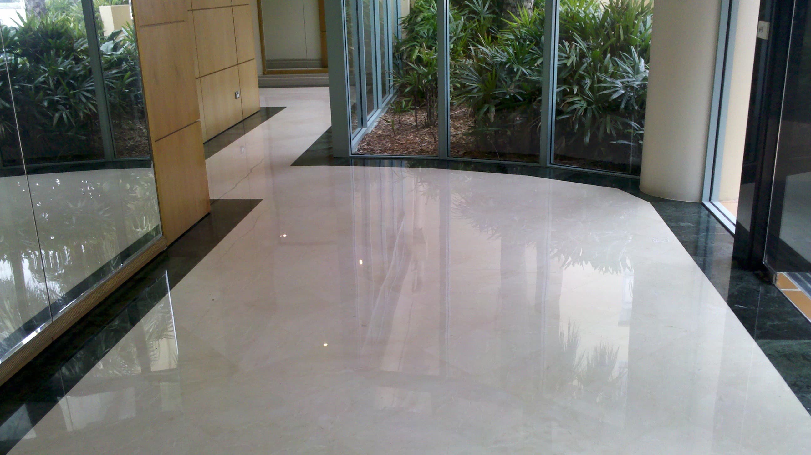 Polished cream marble foyer floor with a dark stone border, restored to a full reflective finish