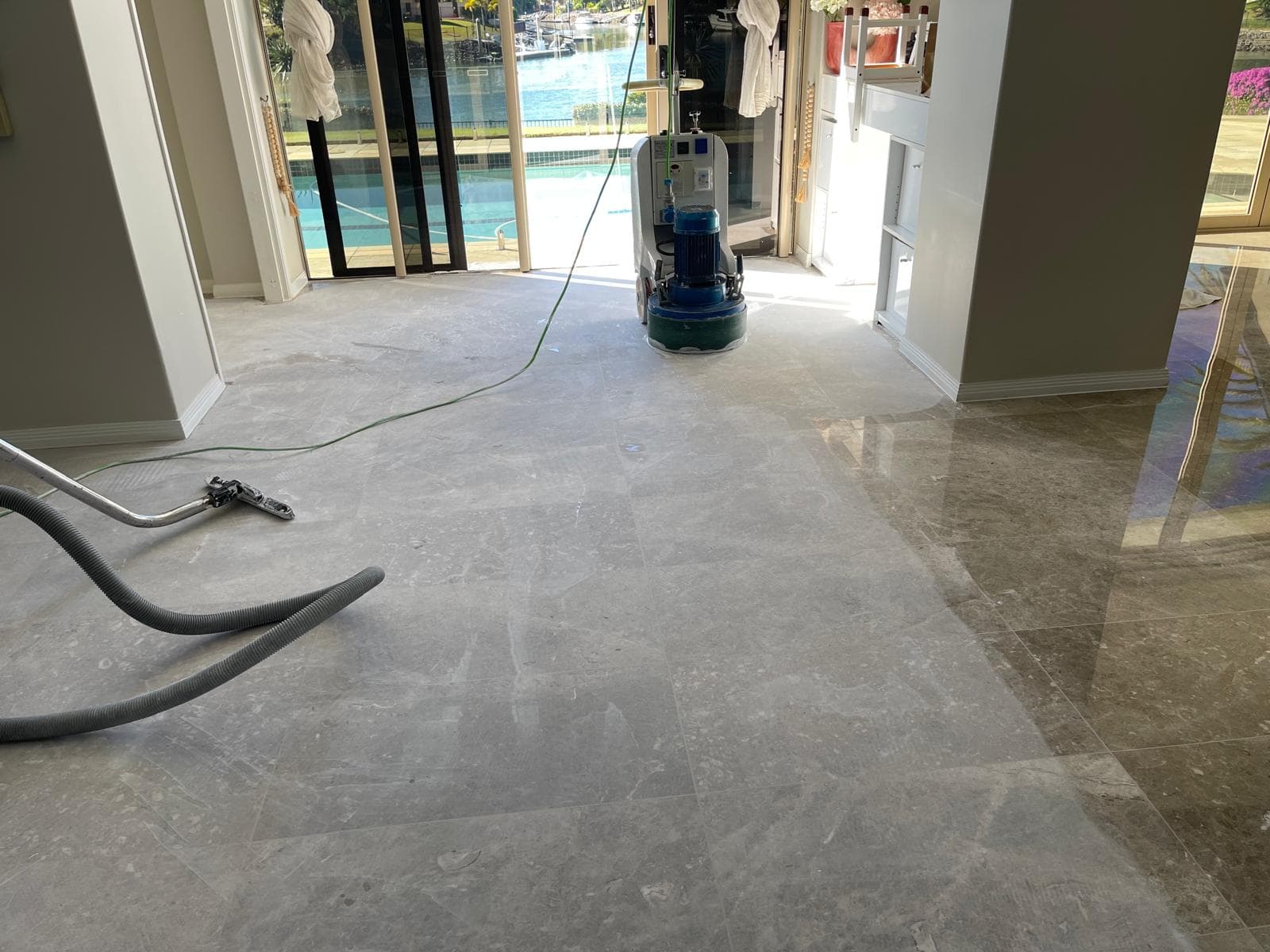 Planetary grinding machine part-way across a marble floor